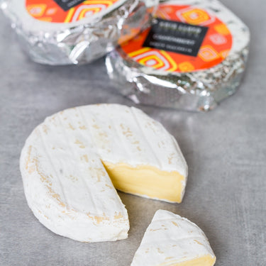 Camembert in packaging and out of packaging with slice taken out
